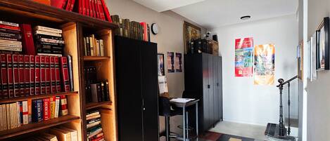 Ein Arbeitsraum mit Bücherregalen, einem Schreibtisch und einem Stuhl.