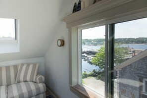 Een kamer met een groot raam met uitzicht op een jachthaven en water.