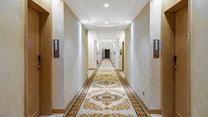 A long, narrow hallway with a patterned carpet and wooden doors on either side. - Vienna Classic Hotel (Tongren Jiangkou) (Jiangkou)
