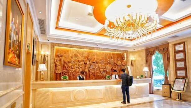 A hotel reception area with a marble floor, a large chandelier, and a reception desk with staff. - Vienna Classic Hotel (Tongren Jiangkou) (Jiangkou)