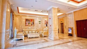 A spacious lobby with a high ceiling, elegant furniture, and a large painting on the wall. - Vienna Classic Hotel (Tongren Jiangkou) (Jiangkou)