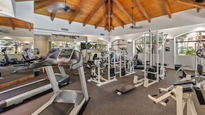 A gym with treadmills, weight machines, and a wooden ceiling.