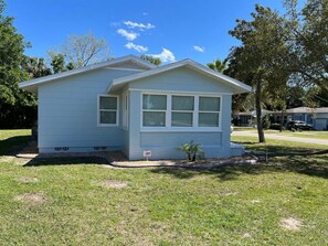 A small, single-story house with a gabled roof, a front porch, and a small front yard. - Changes In Latittude Retreat (Daytona Beach)