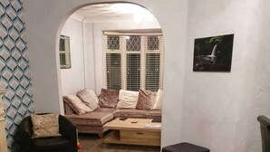 A living room with a sofa set, a coffee table, and a patterned rug. - Waterfalls House - property akin Waterfall Country (Pontneddfechan)