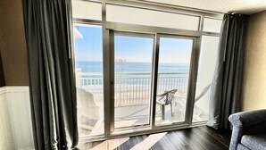 A room with a large sliding glass door leading to a balcony with a view of the beach. - Paramount Plus/Oceanfront/New (Myrtle Beach)