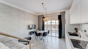 Una cocina moderna con comedor, televisor montado en la pared y vistas al exterior.