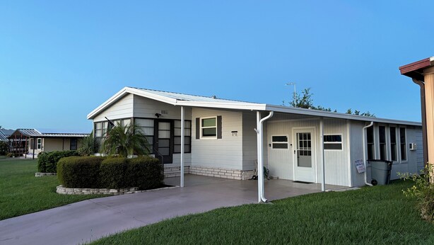 A single-story house with a covered porch, a front door, and a small front yard with a hedge. - Sunshine and Relax! (Zephyr Hill)