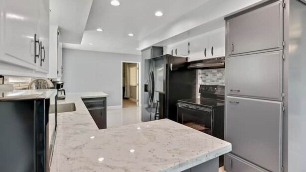 A modern kitchen with a marble countertop, stainless steel appliances, and a sleek design.
