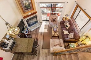 Cozy living area with a fireplace, dining table, and comfortable seating. Enjoy the view from the balcony.