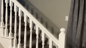 Portaat, joissa on valkoiset kaiteet ja matolla päällystetyt askelmat.