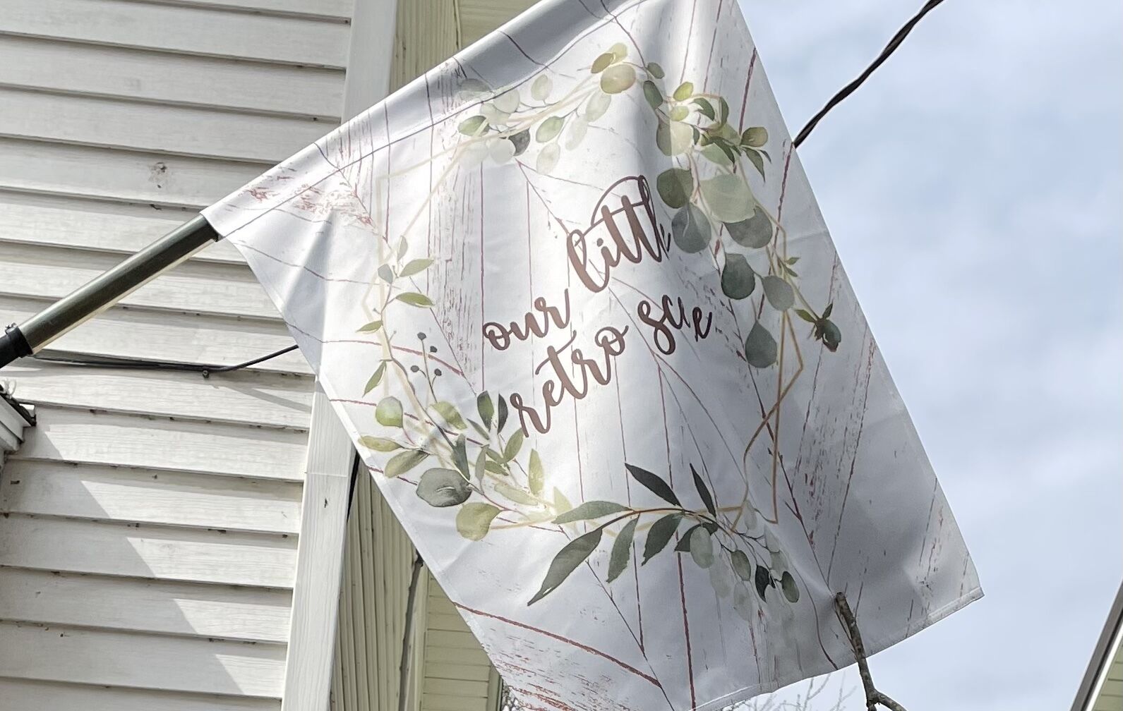 Een vlag met de tekst ‘our little retro style’ en een bloemenpatroon.