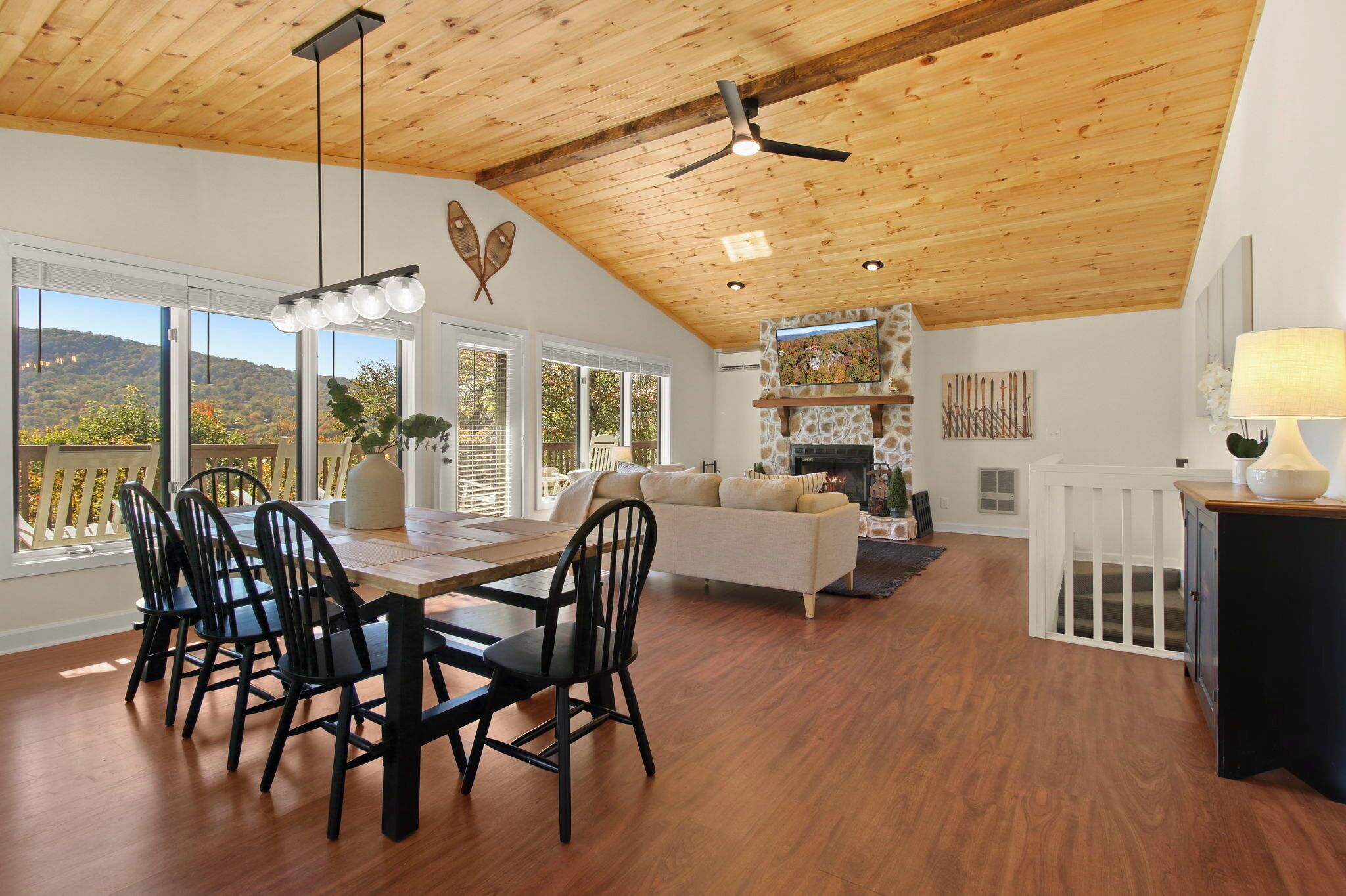 A spacious living area with a dining table, chairs, a sofa, and a fireplace.