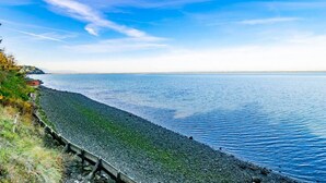 A coastal view with a pebble beach and a wooden fence. - Rm 4 Sequim lavender · 4-Water View-Beach access-Sequim's Lavender Room (Sequim)