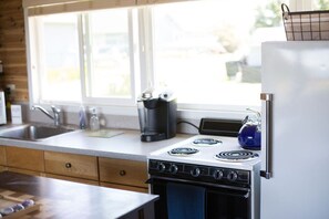 A kitchen with a stove, sink, and a window. - Rm 4 Sequim lavender · 4-Water View-Beach access-Sequim's Lavender Room (Sequim)