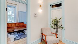 A living room with a sofa, a chair, a coffee table, and a plant. - Suite 3 | Historic Art City Inn (Springville)