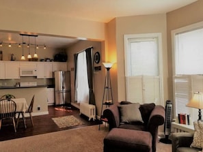 A compact living space with a kitchenette, a dining area, a sofa, and a standing lamp. - Heart of Downtown 2-Bedroom Apt, Mountain Views, Full Kitchen, Walk to Eats (Glenwood Springs)