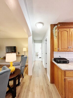 A modern kitchen with wooden cabinets, a countertop, and a built-in oven. - Katy Trail Rest Stop (Sedalia)