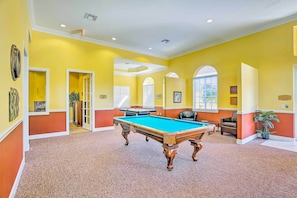 A pool table in a room with yellow walls and a carpeted floor. - Work, Swim + Play in Ft Myers: Resort Condo Stay! (Fort Myers)