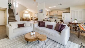 A spacious living area with a white sofa, a ceiling fan, and a kitchen in the background. - 5 Mi to Disney! Family Getaway w/ Poolside Oasis (Kissimmee)