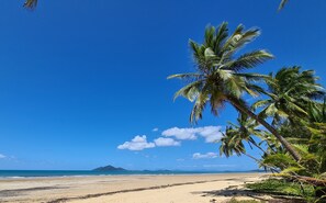 Di pantai, pasir putih, handuk pantai, dan berkayak