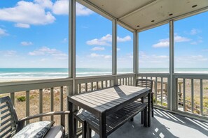 A covered outdoor area with a table and chairs, overlooking a beach. - Beautiful Direct Oceanfront Atlantic Beach Paradise (Atlantic Beach)
