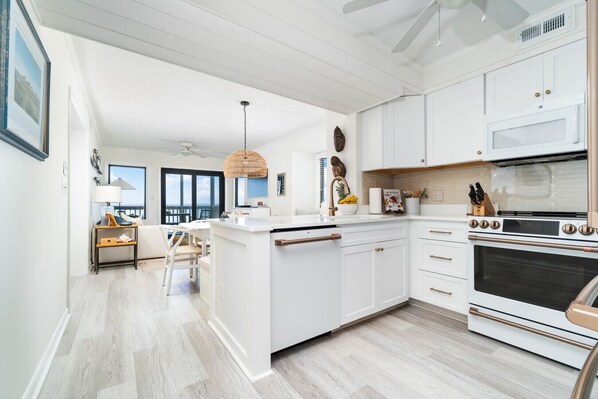 A modern kitchen with white cabinetry, a central island, and a large oven. - Beautiful Direct Oceanfront Atlantic Beach Paradise (Atlantic Beach)