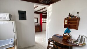 A kitchen with a white refrigerator, a wooden table with a barrel, and a hanging light fixture. - LES VILLAS PAMEYAQUE/ LA VILLA PAME with swimming pool, facing the Caribbean Sea (Rivière-Salée)