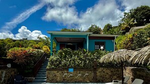 A swimming pool with a stone wall and lounge chairs, a staircase leading to a house, and a clear blue sky. - LES VILLAS PAMEYAQUE/ LA VILLA PAME with swimming pool, facing the Caribbean Sea (Rivière-Salée)