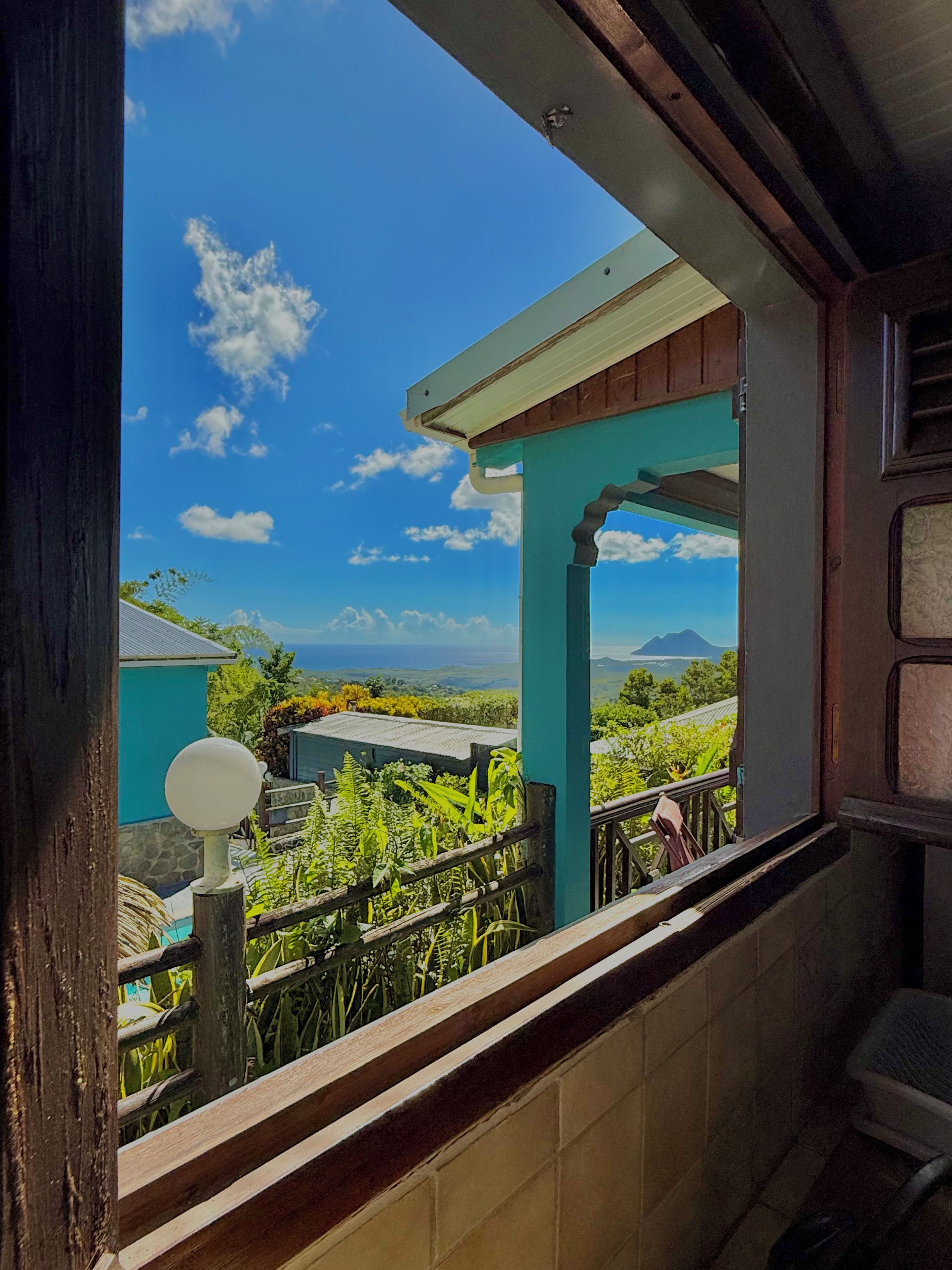 Een balkon met uitzicht op een bergachtig landschap en een heldere lucht.