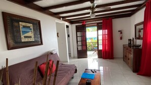 A room with a wooden ceiling, a sofa, a coffee table, and a painting on the wall. - LES VILLAS PAMEYAQUE/ LA VILLA PAME with swimming pool, facing the Caribbean Sea (Rivière-Salée)