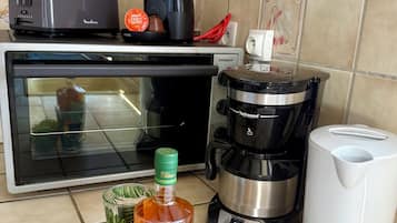 A kitchen with a coffee maker, a toaster, a blender, and a bottle of Clements wine.