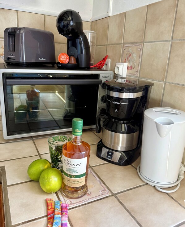 A kitchen with a coffee maker, a toaster, a blender, and a bottle of Clements wine. - LES VILLAS PAMEYAQUE/ LA VILLA PAME with swimming pool, facing the Caribbean Sea (Rivière-Salée)