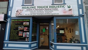 Um edifício com a placa 'Healing Touch Holistic' para clínica médica.