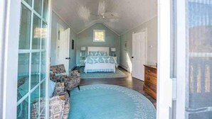 Un dormitorio con una cama grande, un tocador y una ventana.