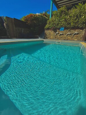 A clear blue pool with stone walls and a wooden fence. - VILLAS PAMEYAQUE / LA YAQUE with a pool and a magnificent view of the Caribbean Sea (Rivière-Salée)