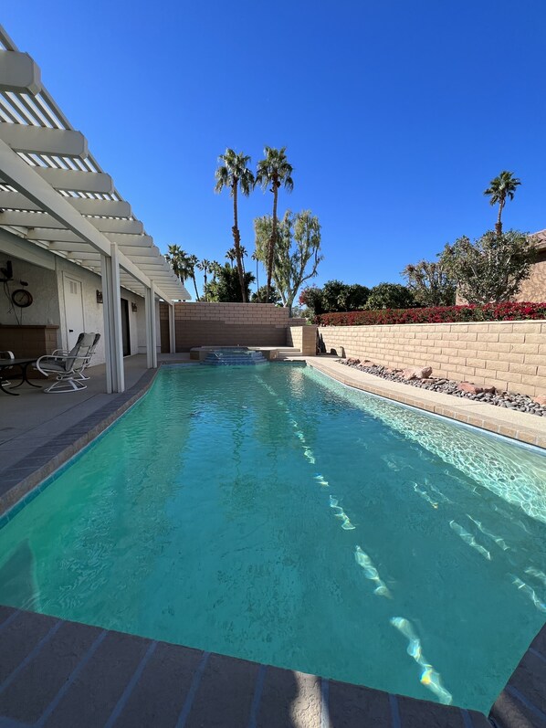 Relax by the inviting pool surrounded by lush greenery and comfortable lounge chairs.