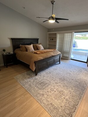 Cozy retreat with a dark bed frame, area rug, and shelving unit.