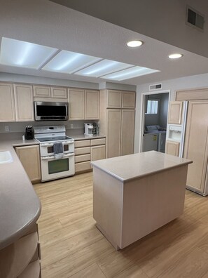 Enjoy cooking in this well-equipped kitchen with a central island, oven, and microwave.