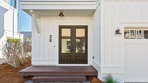 A white house with a dark brown front door, number 28, and a small porch with steps. - Ocean View ☀️1 Lot from the Gulf | 52 10-Star Reviews | Beach Gear ☀️Comm Pool (Santa Rosa Beach)