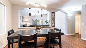 Een eethoek met een grote tafel, vier stoelen en een decoratief middelpunt.