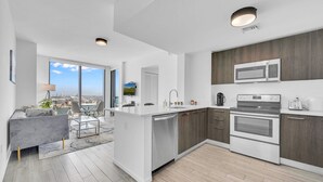 Una cucina moderna con una grande isola, elettrodomestici integrati e vista sulla città.