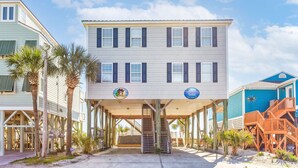 A multi-story building with a covered walkway and stairs leading to a deck.