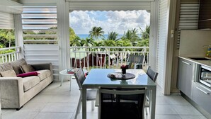 Un balcon équipé d’une table et de chaises pour les repas, d’un canapé et d’un coin cuisine.