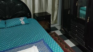 A bedroom with a bed, a wardrobe, a ceiling fan, and an air conditioner. - Al Dahar apartments Hurghada  (Hurghada)