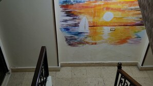 A staircase with a hand-painted sunset mural on the wall. - Al Dahar apartments Hurghada  (Hurghada)