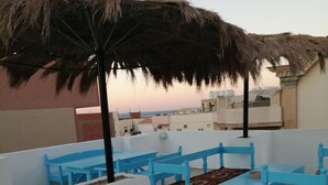 A rooftop terrace with blue furniture and a thatched umbrella. - Al Dahar apartments Hurghada  (Hurghada)