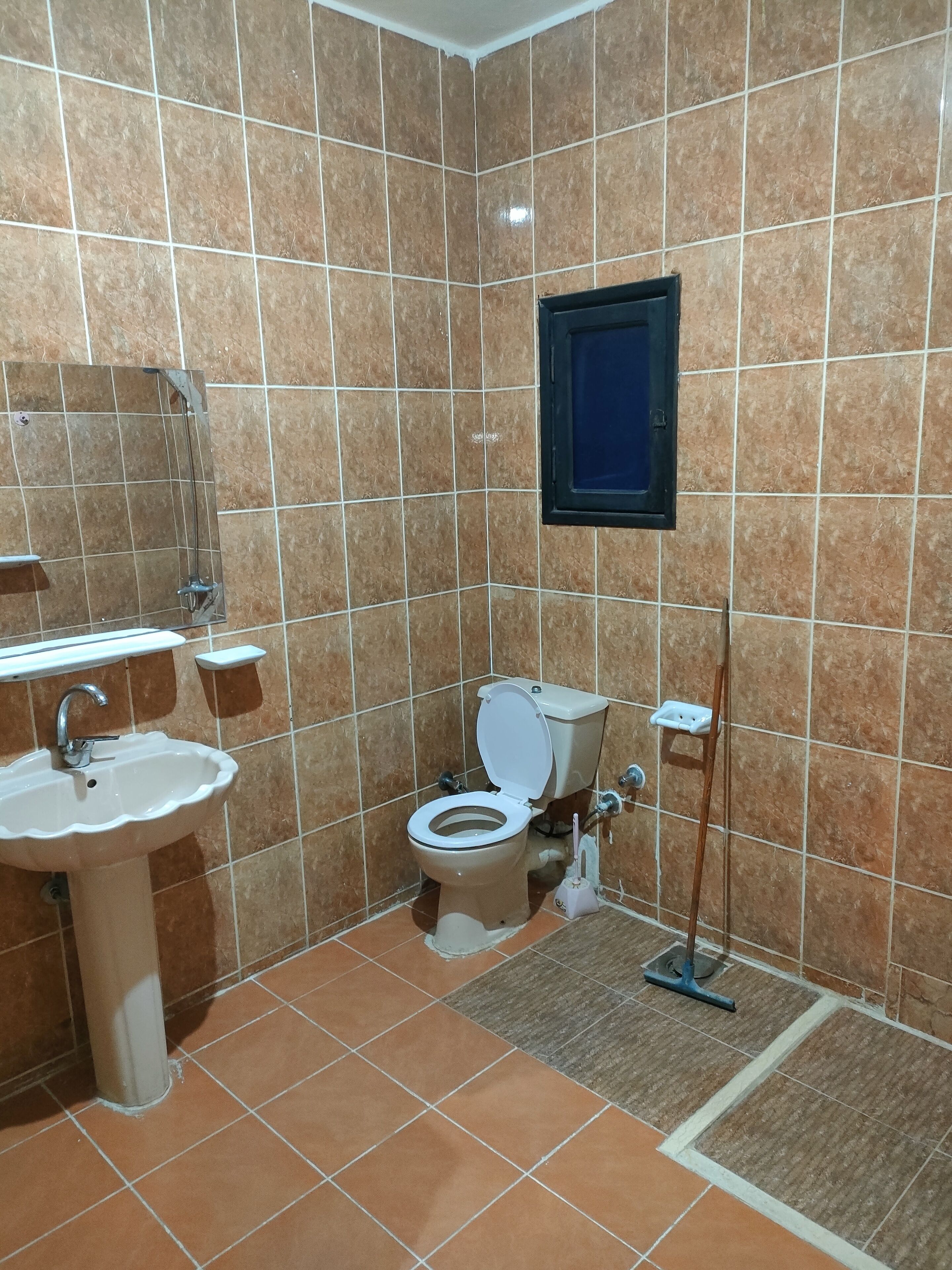 Un baño con lavabo, inodoro y ventana.