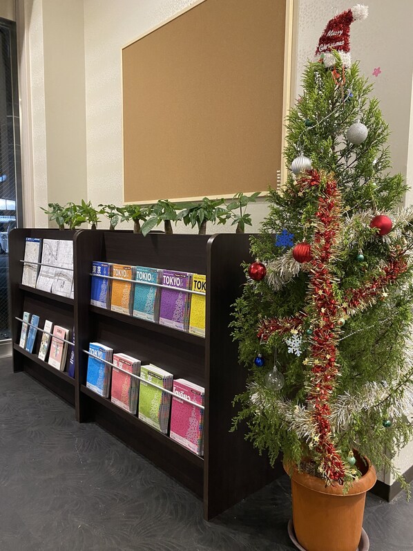 A bookshelf with travel guides and a Christmas tree with decorations.