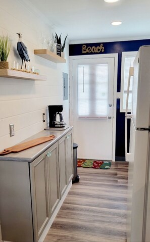 Enjoy cooking in this well-equipped kitchen with a coffee maker, trash bin, and ample counter space.