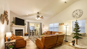 A living room with a leather sofa, a flat-screen TV, a fireplace, and a Christmas tree. - 3BR Fall Creek Condo Near Table Rock Lake + Branson Attractions | FC 39-2 (Branson)